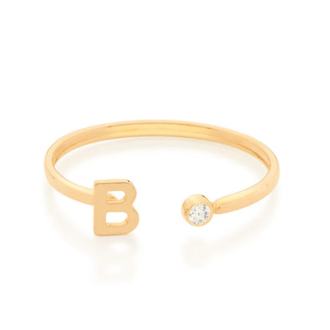 Imagem de fundo branco com um anel no centro da marca Rommanel, código 512843. Anel na cor dourada folheado a ouro, anel ajustável formado por letra B de um lado e 1 zircônia de 2,0 mm do outro lado.