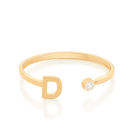 Imagem de fundo branco com um anel no centro da marca Rommanel, código 512843. Anel na cor dourada folheado a ouro, anel ajustável formado por letra D de um lado e 1 zircônia de 2,0 mm do outro lado.