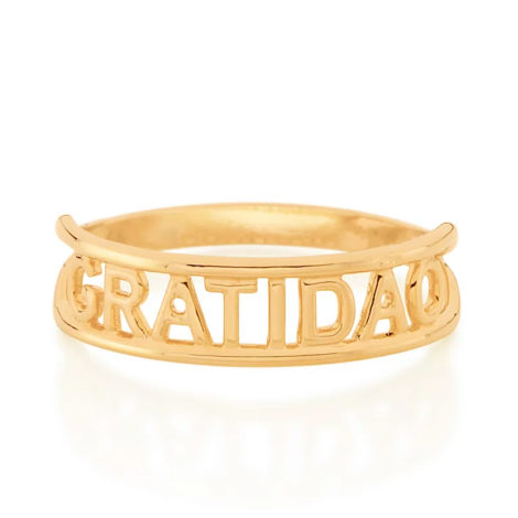 Imagem de fundo branco com um anel no centro da marca Rommanel, código 512850. Anel na cor dourada folheado a ouro, anel skinny ring duplo aro escrito gratidão no centro.