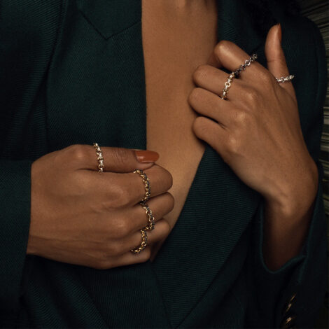 Foto de mãos de modelo de pele negra, usando o anel elo com zircônias folheado a ouro e antialérgico. Código 1911285
