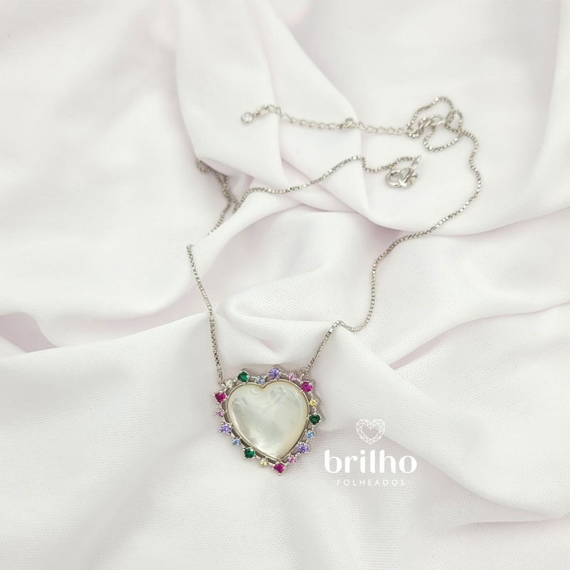 Foto fundo neutro do colar coração madrepérola prateado folheado a ródio branco da marca Sabrina Joias revendido pela Brilho Folheados. Código R1900710