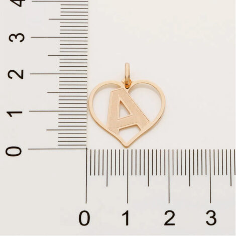Foto com imagem de régua medindo pingente coração com letra folheado a ouro, cor dourado, da marca Rommanel. Código 542211